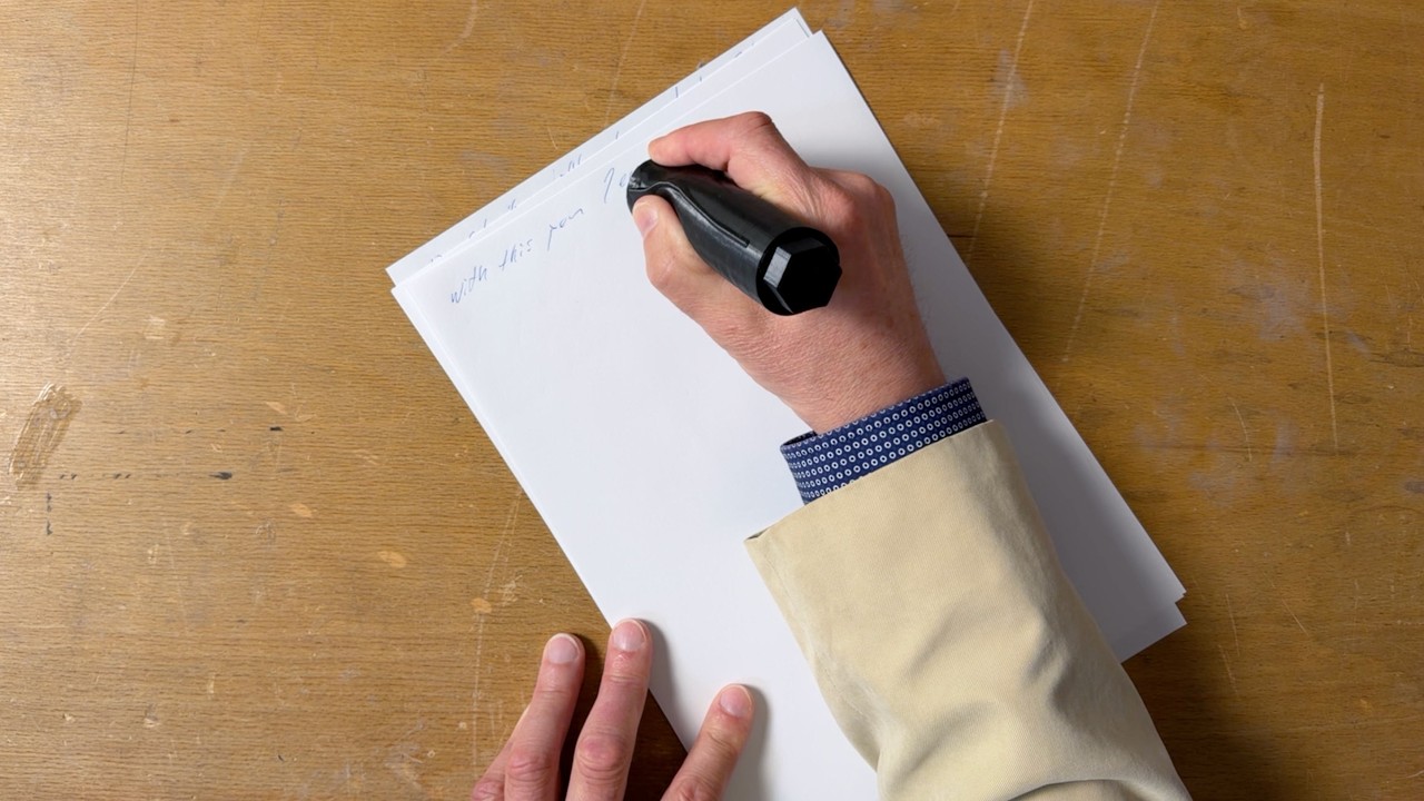 Person holding an ergonomic pen